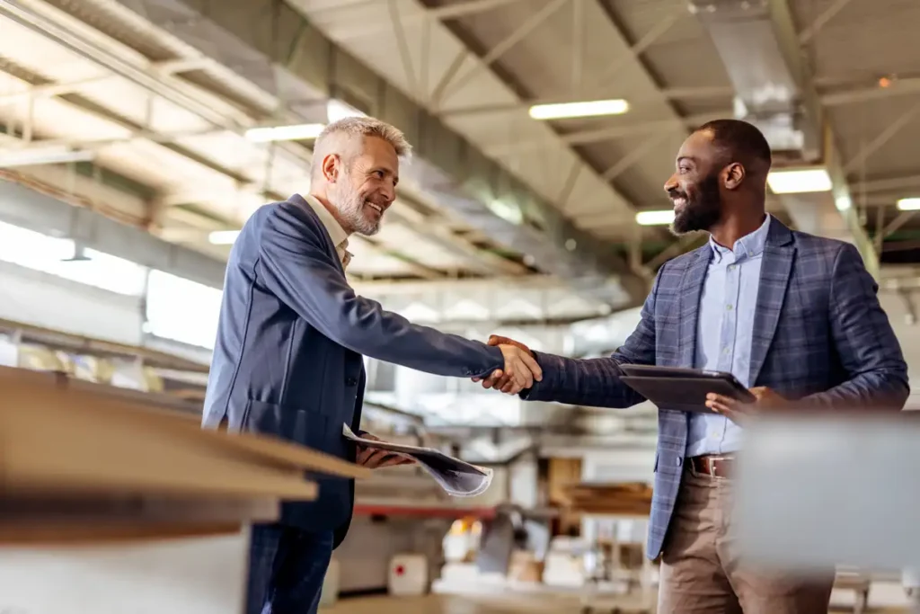Des hommes d’affaires professionnels se serrent la main lors d’un accord commercial dans une usine moderne